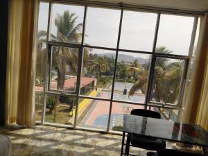a room with a large window looking out at a pool at Hotel Emmanuel in Chepén