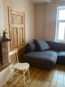 a living room with a blue couch and a chair at St Johns sunny side apartment in Cēsis
