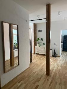 a living room with a mirror and a wooden floor at St Johns sunny side apartment in Cēsis +1 photo