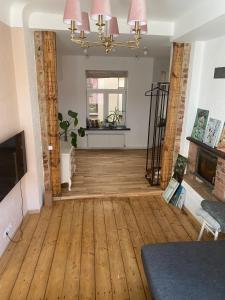 a living room with a wooden floor and a fireplace at St Johns sunny side apartment in Cēsis