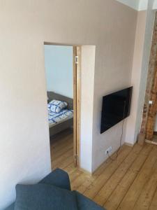a room with a bedroom with a bed and a television at St Johns sunny side apartment in Cēsis