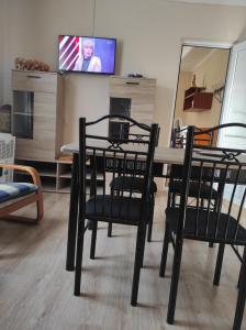 a dining room with a table and chairs and a tv at Apartment Temo in Ureki