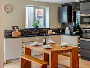 a kitchen with a wooden table with wine glasses at 2 Bed in Middlesbrough oc-75226 in Great Ayton