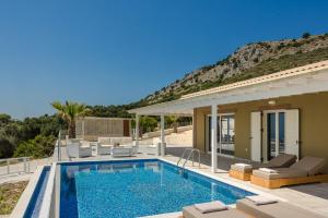 a villa with a swimming pool and a house at Saint Nicholas Villas 5 in Skala