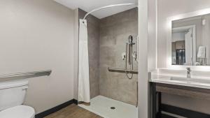 a bathroom with a shower and a toilet and a sink at Studio 6 Richmond, VA - Airport in Sandston