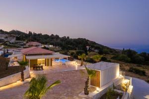 a house with a view of the ocean at night at Saint Nicholas Villas 5 in Skala