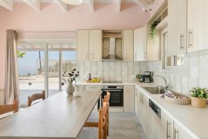 a kitchen with white cabinets and a large counter top at Saint Nicholas Villas 5 in Skala
