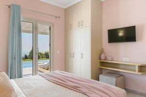 a bedroom with a bed and a tv on a wall at Saint Nicholas Villas 5 in Skala