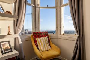 a yellow chair sitting in front of a window at Harbour View - Anstruther in Anstruther
