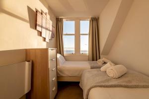 a small room with two beds and a window at Harbour View - Anstruther in Anstruther