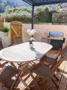a table and chairs on a deck with a grill at Maison Corse avec SPA - La Casa Serena in Ortiporio