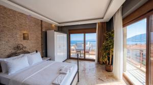 a bedroom with a white bed and a balcony at Stone House Foça Otel in Yenifoça +71 photos