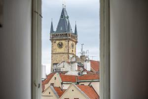 a view of a clock tower from a window at Celine Prague Luxury Hostel in Prague