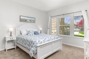 a white bedroom with a bed and a window at Beacon at the Lakes Cozy 2b2b, Grnd Level Condo in Windsor