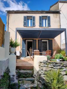 a house with a patio with chairs in front of it at Maison Corse avec SPA - La Casa Serena in Ortiporio