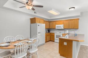 a kitchen with a table and a white refrigerator at Beacon at the Lakes Cozy 2b2b, Grnd Level Condo in Windsor