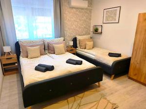 a bedroom with two beds and a window at GRAND HOME Apartman in Sárospatak
