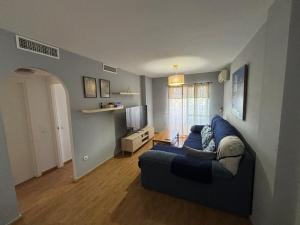 a living room with a blue couch and a tv at Apartamento Benalmarina in Benalmádena