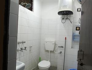 a small bathroom with a toilet and a sink at Scindhia Guest House in Varanasi +34 photos