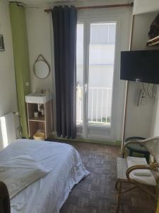 a bedroom with a bed and a large window at Hôtel de la poste in La Celle-sous-Gouzon