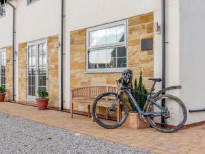 a bike parked next to a building with a bench at 3 Bed in Stokesley oc-77667 in Carlton