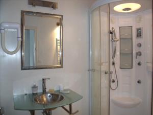 a bathroom with a sink and a shower with a mirror at Location Landes Mimizan Plage in Mimizan-Plage