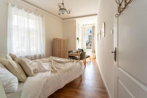 a white bedroom with a bed and a desk at Celine Prague Luxury Hostel in Prague
