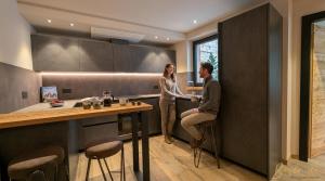 a man and a woman standing in a kitchen at Isolden Green Srl Berlanda Mountain suites in Cavalese +30 photos