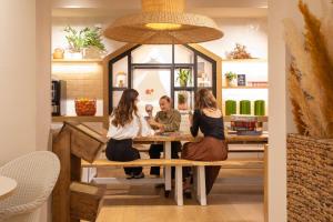 three women sitting at a table in a restaurant at Hôtel Life Marseille VP - Vieux Port in Marseille