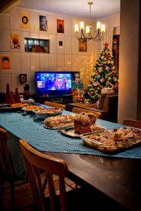 a table with many pizzas on it with a christmas tree at Carcará Hostel Ipanema - Zona Sul POA in Porto Alegre +44 photos