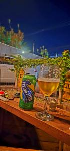 a glass of beer and a can on a wooden table at Carcará Hostel Ipanema - Zona Sul POA in Porto Alegre
