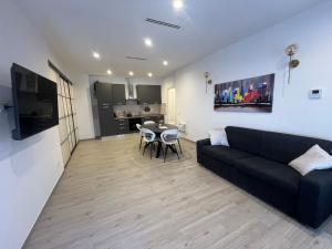 a living room with a black couch and a table at BaseFCO - Vicino Aeroporto e Mare in Isola Sacra