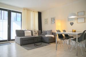 a living room with a couch and a table at Haus Titania App 6 inkl WLAN in Grömitz