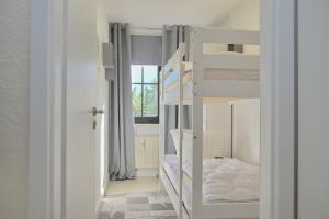a room with two bunk beds and a window at Haus Titania App 6 inkl WLAN in Grömitz