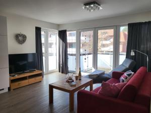 a living room with a red couch and a tv at Ferienwohnung "Strandläufer 1" in Böhl