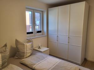 a bedroom with white cabinets and a bed and a window at Ferienwohnung "Strandläufer 1" in Böhl