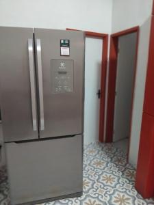 a kitchen with a stainless steel refrigerator in a room at Estalagem Triplex Vermelho in Vitória