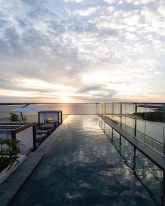 a swimming pool on the roof of a building with the ocean at Alula Hotel Encarnacion in Encarnación