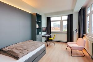 a bedroom with a bed and a desk and a chair at MIAMI House in Hamburg