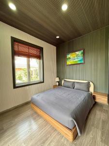 a bedroom with a large bed in a room with a window at Twins Villa Đà Lạt in Khu Chi Lăng +9 photos
