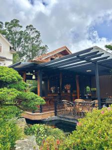 a large wooden deck with chairs and a table at Twins Villa Đà Lạt in Khu Chi Lăng
