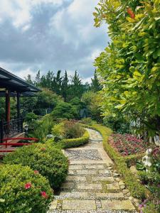a garden with a stone path and flowers at Twins Villa Đà Lạt in Khu Chi Lăng