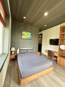 a bedroom with a bed and a desk and a television at Twins Villa Đà Lạt in Khu Chi Lăng