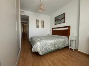 a bedroom with a bed and a wooden floor at Apartamento Benalmarina in Benalmádena