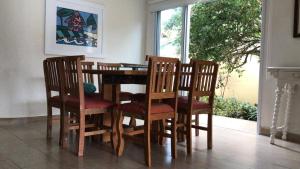 a dining room with a table and chairs and a window at Pousada Allmar in Bertioga