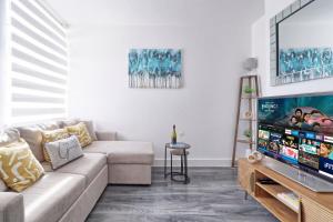 a living room with a couch and a flat screen tv at Colchester 4BR Home, Sleeps 8, Fast WiFi, Perfect for Contractors in Hythe