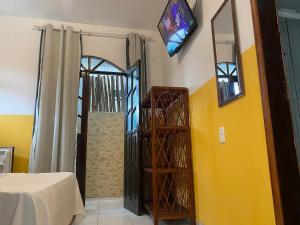 a room with a yellow wall with a door and a staircase at Pousada Sol E Mar in Morro de São Paulo