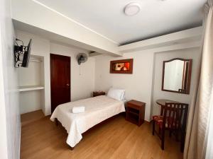 a small bedroom with a bed and a mirror at Hotel Anthony's in Lima