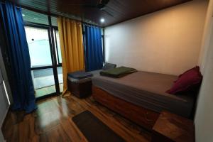 a small bedroom with a bed and a window at Da Java 18 hostel and Homestay Chikmagalur in Chikmagalūr +94 photos
