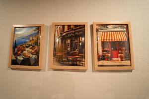 three framed pictures of a restaurant on a wall at Da Java 18 hostel and Homestay Chikmagalur in Chikmagalūr